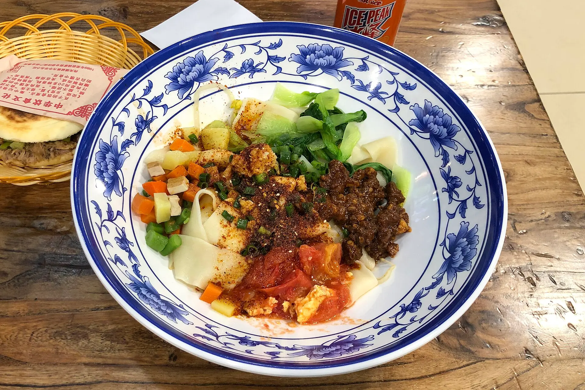 Миска лапши бянбян с овощами и мясом в недорогом кафе в Пекине